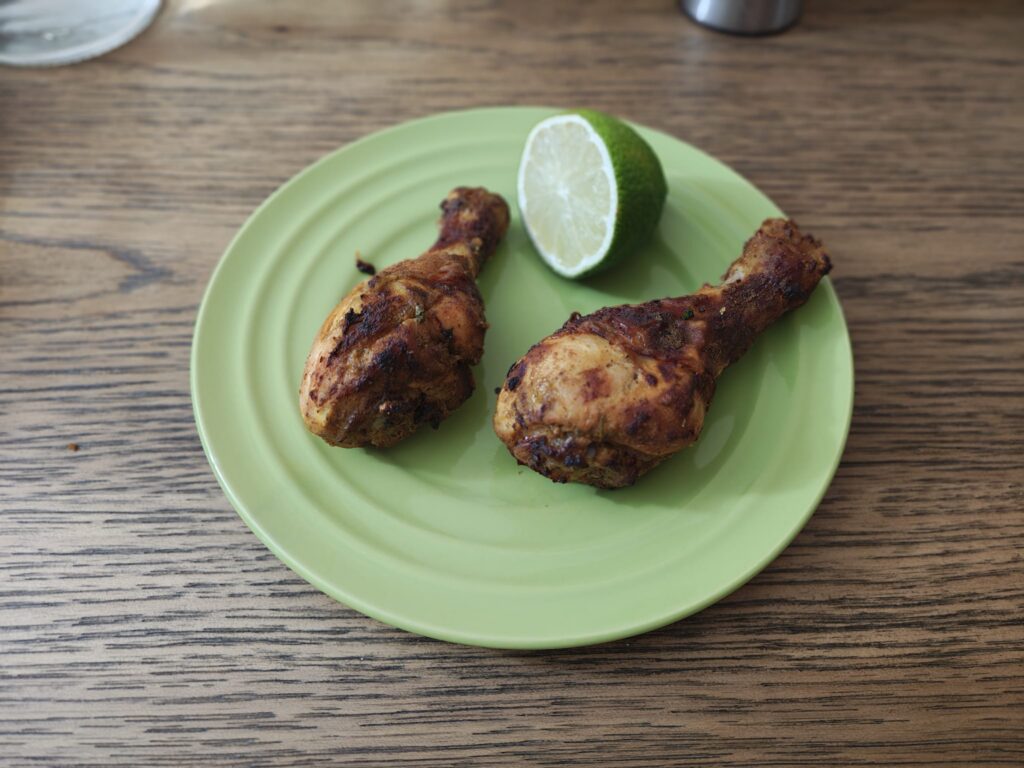 2 pieces of chicken drumsticks on a plate with lemon
