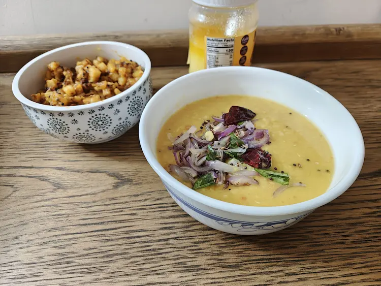 Plain South Indian paruppu dal made with boiled yellow split mung lentils, turmeric, and a touch of ghee in a traditional serving dish.